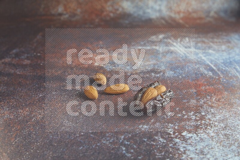 one almond stuffed madjoul date on a rustic reddish background
