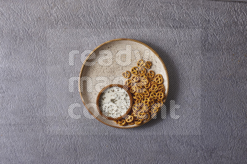 Assorted snacks in pottery bowls on grey background