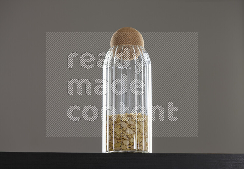 Crushed beans in a glass jar on black background