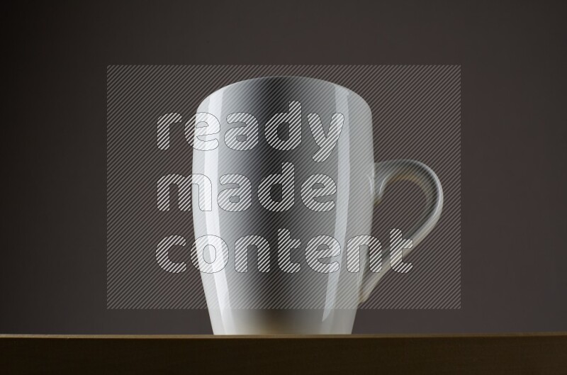 Low angle shot of a white cup on grey background
