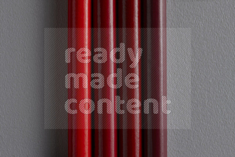 مجموعة من أقلام الرصاص الملونة مرتبة لتعرض تدرجا من الألوان الحمراء علي خلفية رمادية