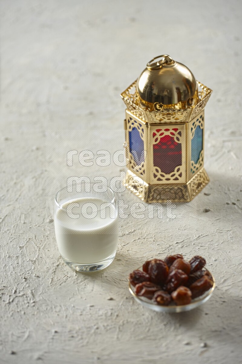 A golden lantern with different drinks, dates, nuts, prayer beads and quran on textured white background