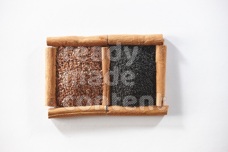 2 squares of cinnamon sticks full of flaxseeds and black seeds on white flooring
