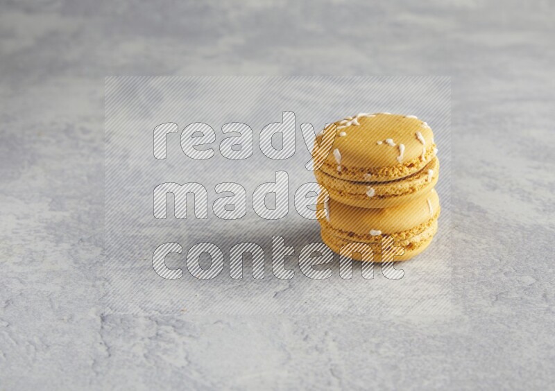 45º Shot of two Yellow Piña Colada macarons  on white  marble background
