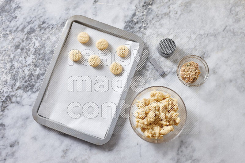 Kahk step by step with its ingredients ghee, sugar, flour, sesame, yeast, water and kahk flavor on grey marble background