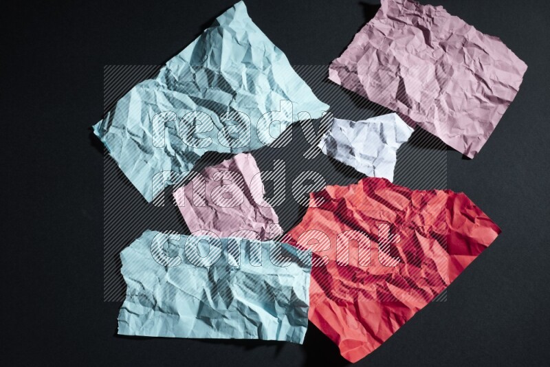 Crumpled multicolored paper on black background