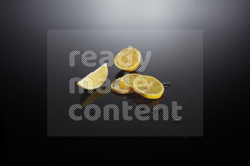 Lemon slices with water drops, and droplets on black background