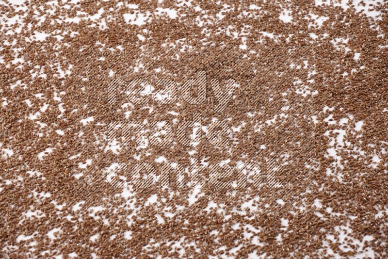 حبوب بذر الكتان متناثرة علي خلفية بيضاء