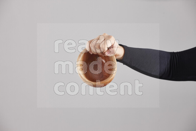 امرأة ترتدي عباءة سوداء تحمل أدوات خشبية مختلفة في أوضاع متعددة