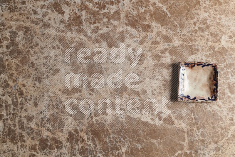 A decorative pottery plate on beige marble background