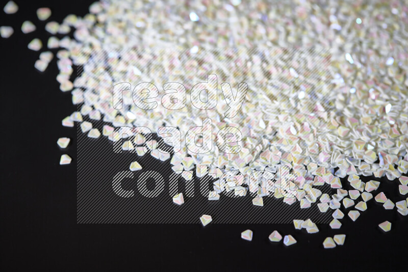 Colorful plastic shards for decoration scattered on a black background