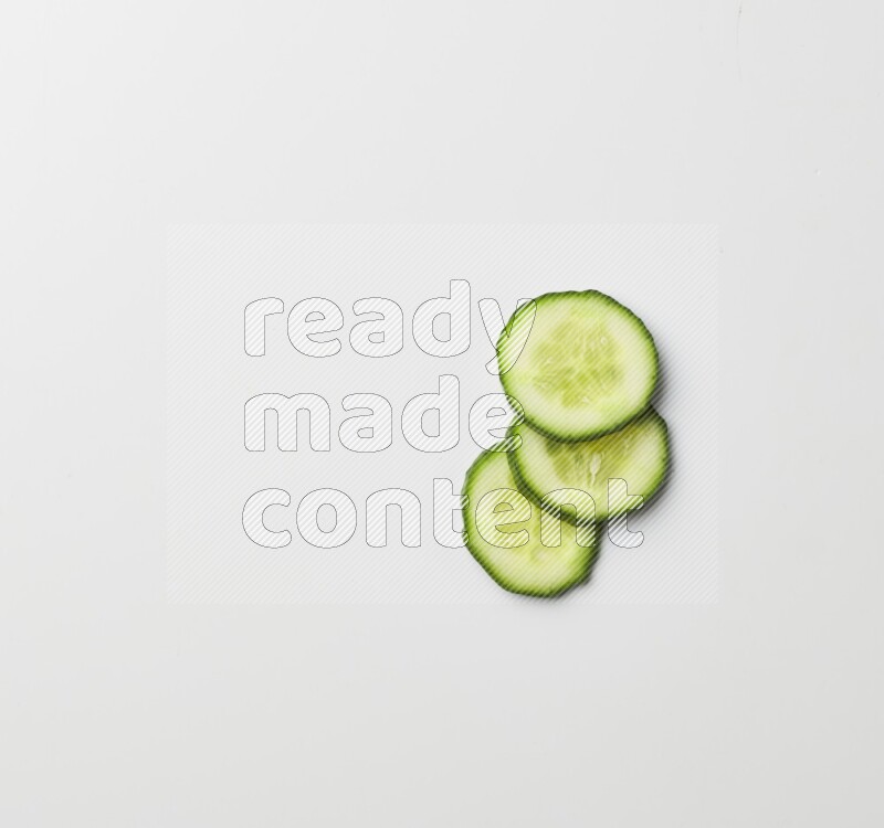 three cucumber slices on white background