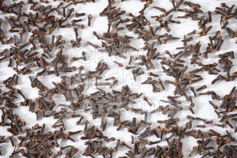 Cloves spread on white flooring