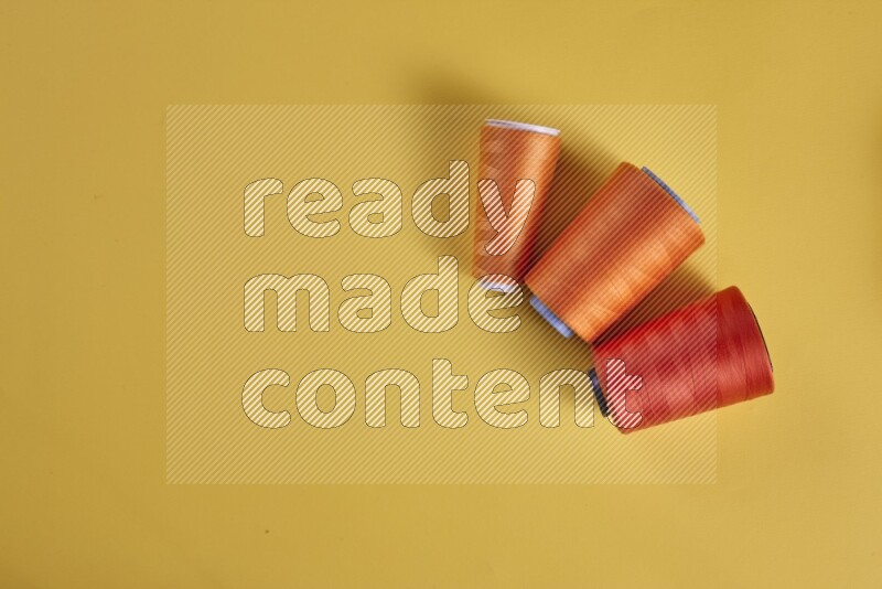An orange collection of sewing and tailoring tools arranged on a yellow background