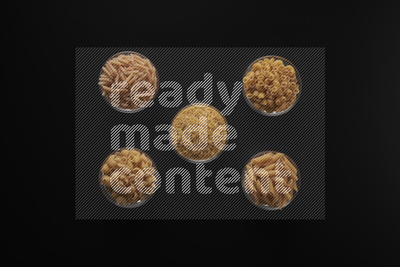 أنواع مختلفة من المعكرونة في أوعية زجاجية علي خلفية سوداء