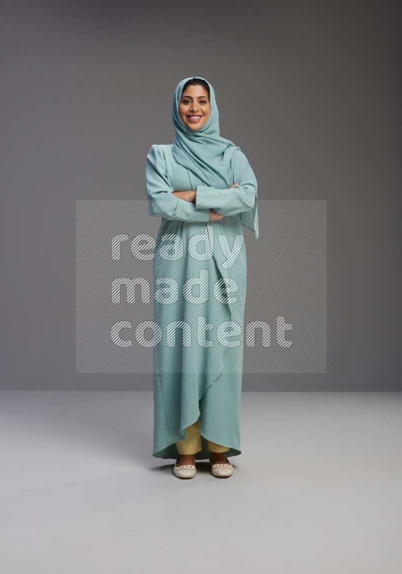 Saudi Woman wearing Abaya standing with crossed arms on Gray background