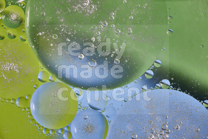Close-ups of abstract oil bubbles on water surface in shades of green and blue