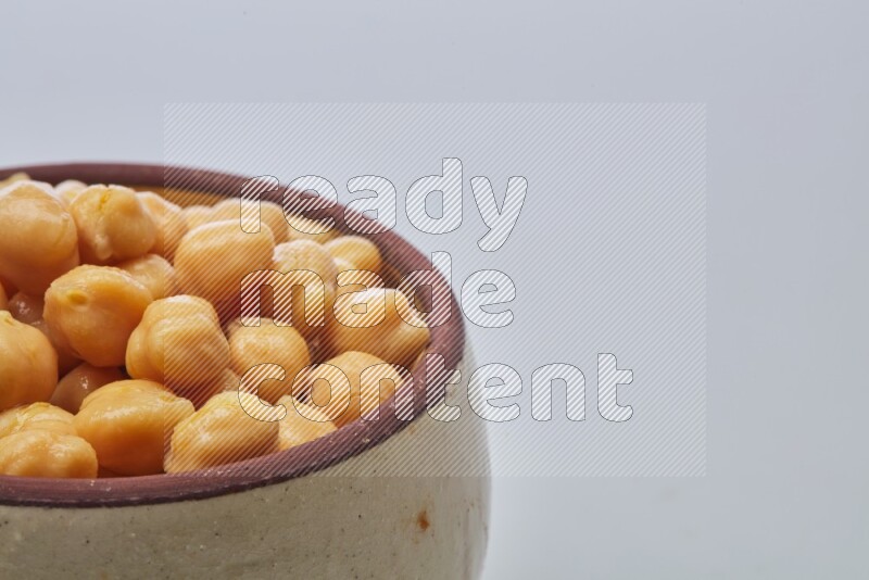 Close up shot of boiled chickpeas in a container on white background