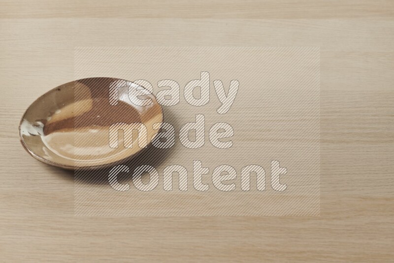 A multicolored pottery plate on light wooden background