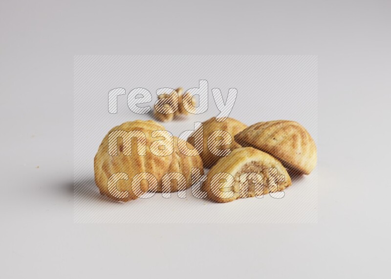 Five Pieces of Maamoul filled with walnut paste  one of them is cut with direct on white background