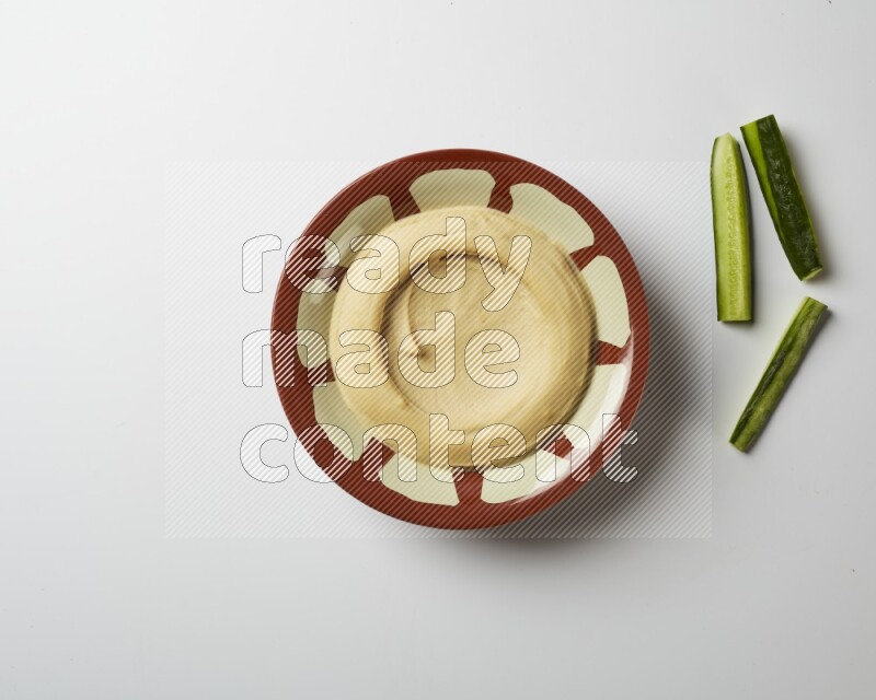 Plain hummus in a traditional plate on a white background