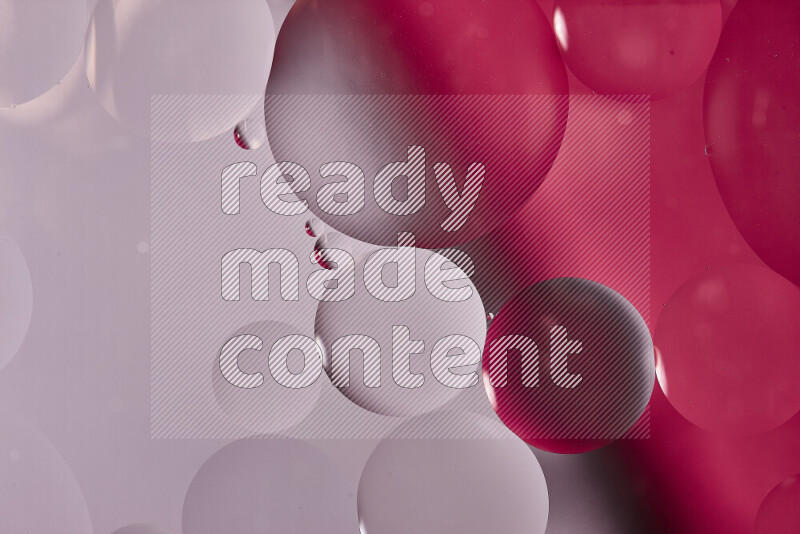 Close-ups of abstract oil bubbles on water surface in shades of white and pink