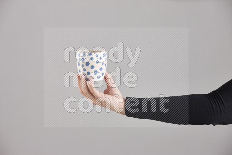A woman in black abaya holding different pottery essentials in different positions