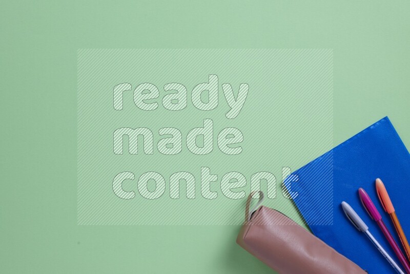 Different school supplies on green background