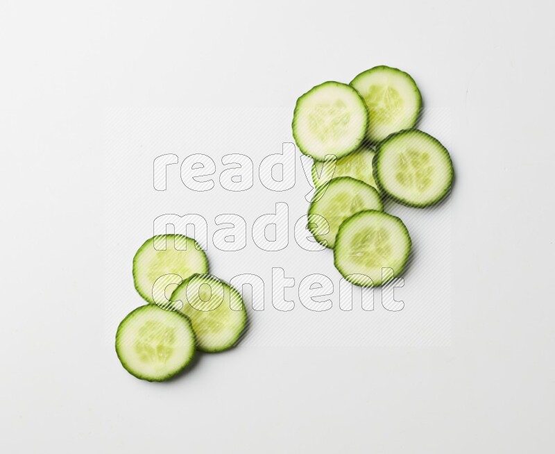 Multiple cucumber slices on white background