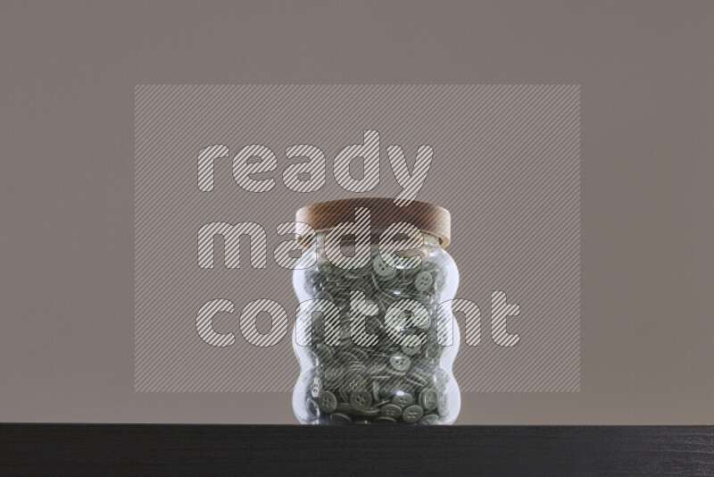 Buttons in a glass jar on black background