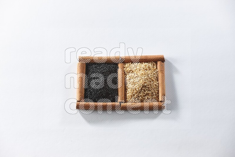 2 squares of cinnamon sticks full of sesame and black seeds on white flooring