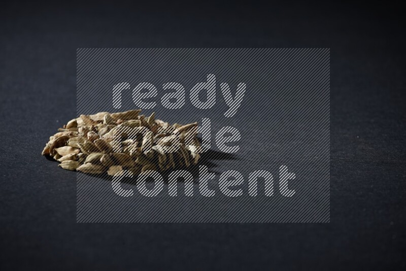 Cardamom in a circle shape on black flooring