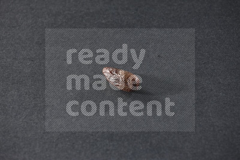 حبة واحدة من البلح المجفف علي خلفية سوداء