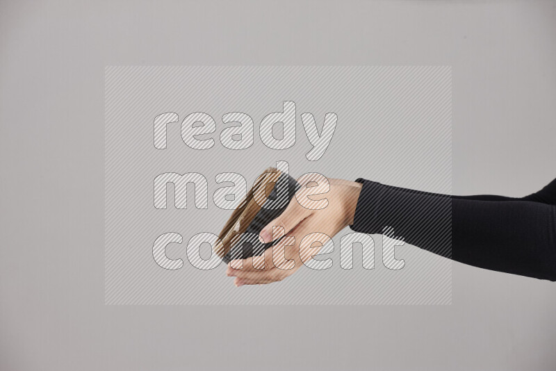 A woman in black abaya holding different pottery essentials in different positions