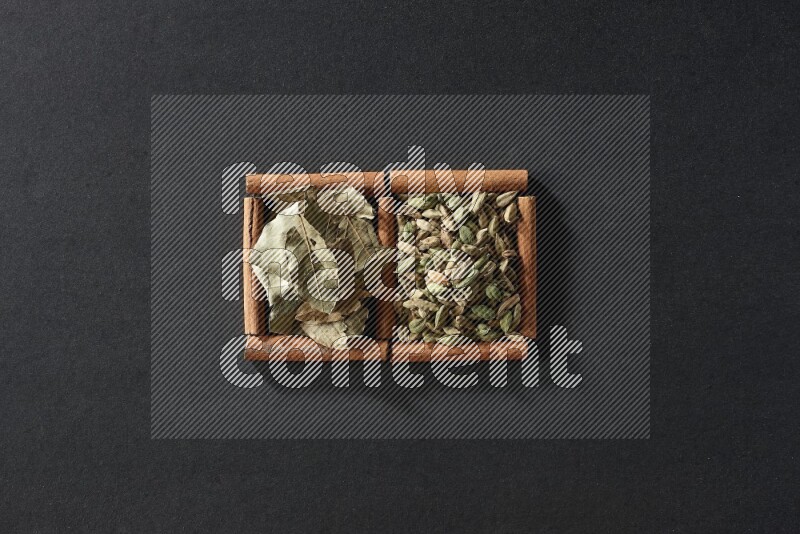 2 squares of cinnamon sticks full of cardamom and bay laurel leaves on black flooring