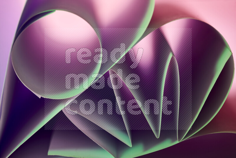 عرض فني لطيات الورق تخلق مزيج من الأشكال الهندسية، مضاءة بإضاءة ناعمة بدرجات اللون الأخضر والارجواني