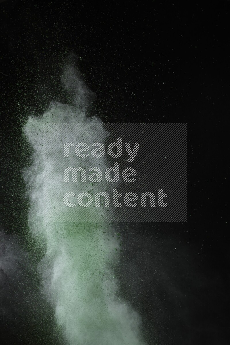 A side view of green powder explosion on black background