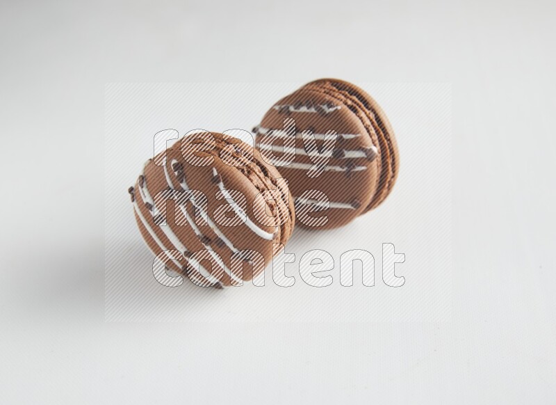 45º Shot of two Brown white Chocolate Caramel macarons on white background