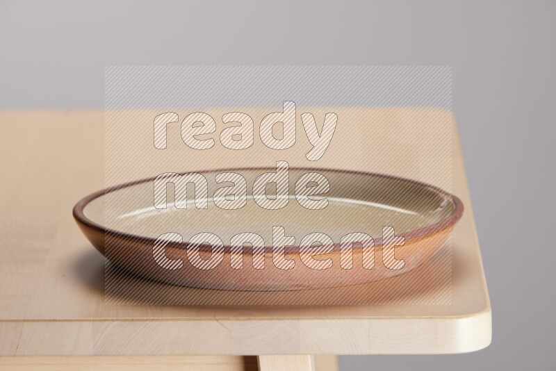multi-colored pottery Plate on a wooden table edge