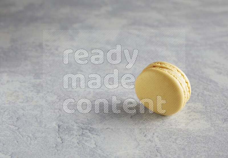 45º Shot of Yellow Vanilla macaron on white  marble background