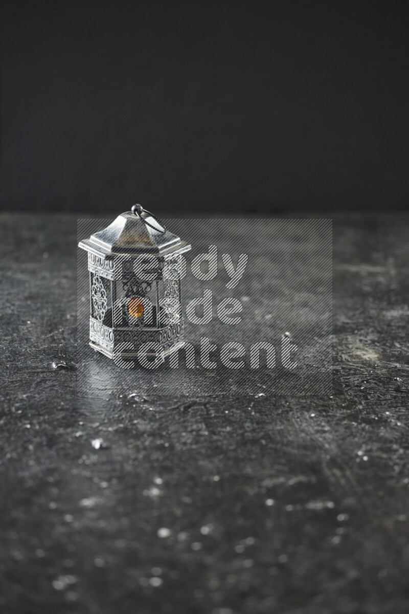 A lantern placed on a textured black background