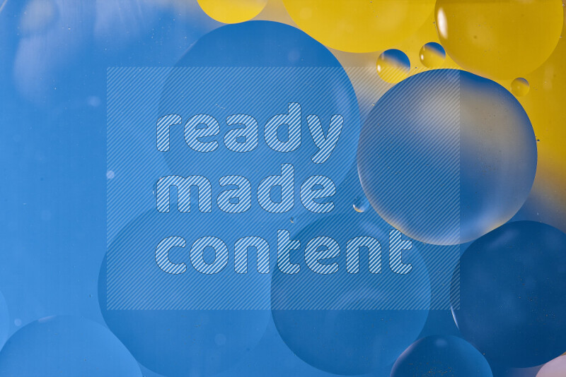 Close-ups of abstract oil bubbles on water surface in shades of blue and yellow