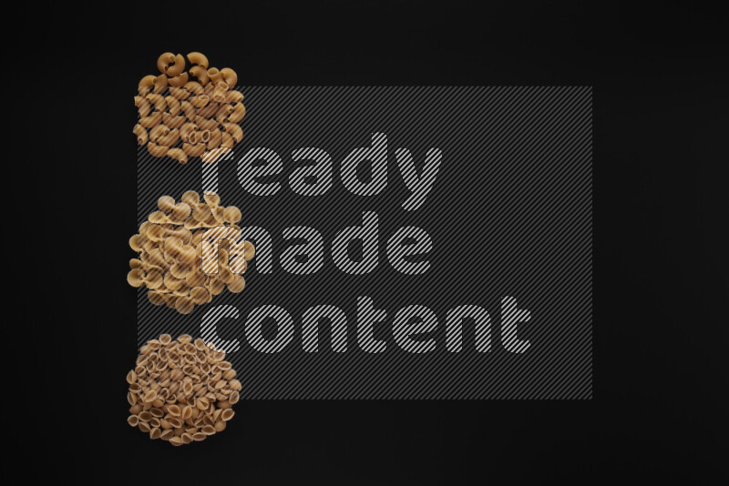 Different pasta types in 3 bunches on black background