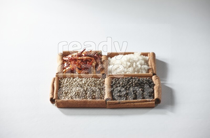4 squares of cinnamon sticks full of red chilis, salt, white pepper, and black pepper on white flooring