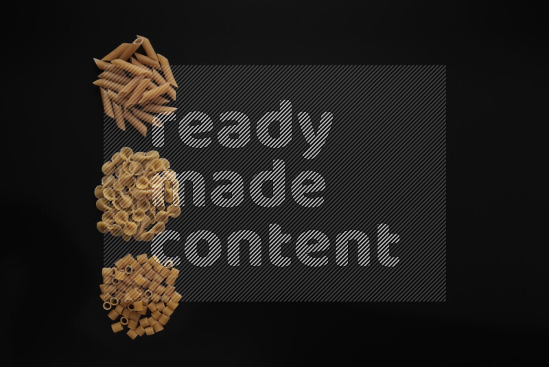 Different pasta types in 3 bunches on black background