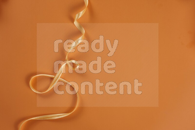 مجموعة من أدوات الخياطة والتفصيل صفراء اللون على خلفية برتقالية