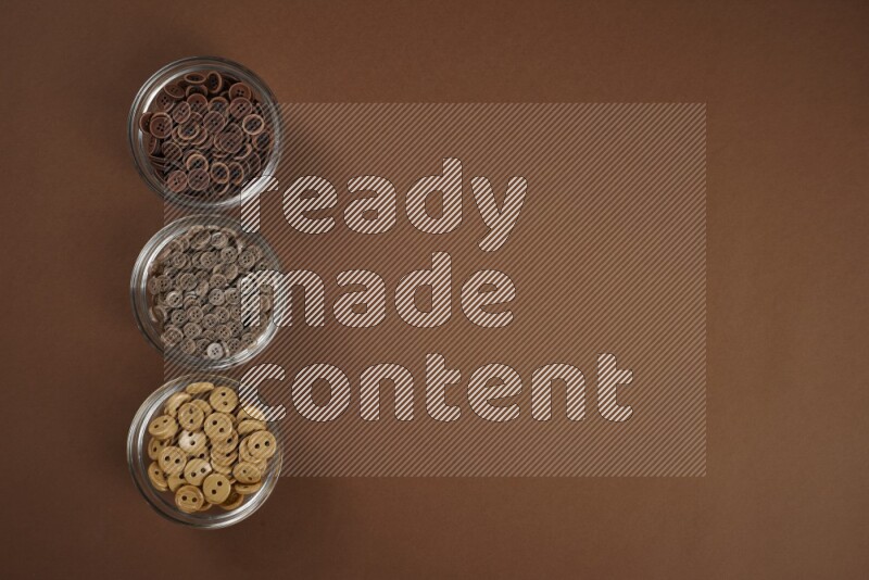 A brown collection of sewing and tailoring tools arranged on a brown background