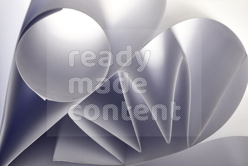 An artistic display of paper folds creating a harmonious blend of geometric shapes, highlighted by soft lighting in grey