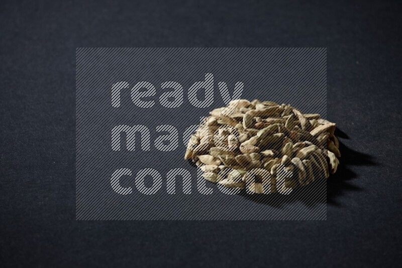 Cardamom in a circle shape on black flooring