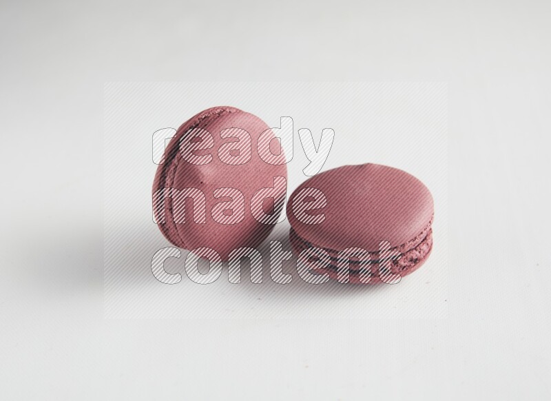 45º Shot of two Red Cherry macarons on white background